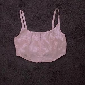 A satin baby pink corset top with flowers and butterflies embroidered